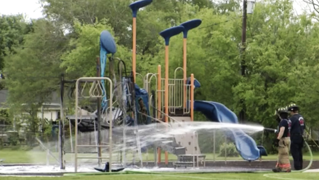 Firemen spraying down burnt playground